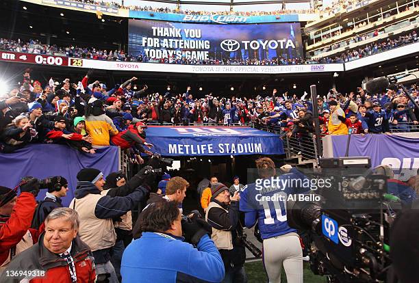 Fans cheer as Eli Manning of the New York Giants runs off of the field after the Giants won 24-2 against Atlanta Falcons during their NFC Wild Card...