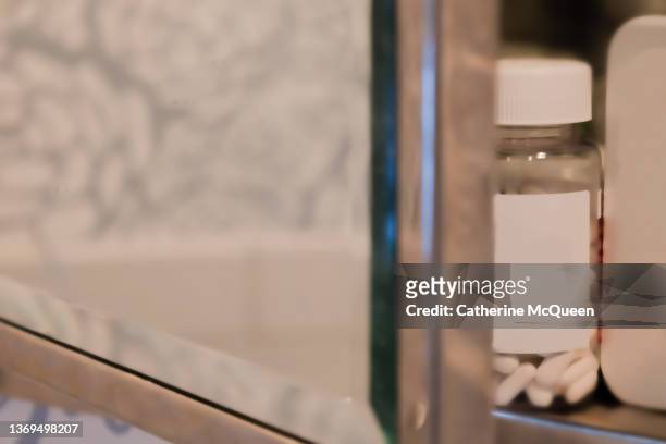 inset glass medicine cabinet in bathroom with door slightly ajar - prescription drugs dangers stock pictures, royalty-free photos & images
