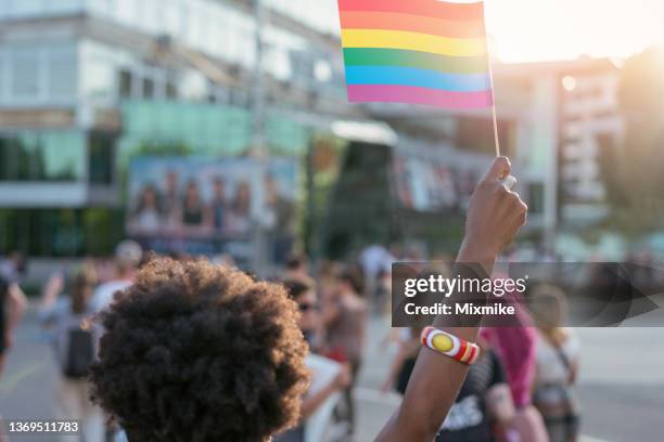 mulher étnica africana nova que acena a bandeira do orgulho do arco-íris no festival do amor - respeito - fotografias e filmes do acervo