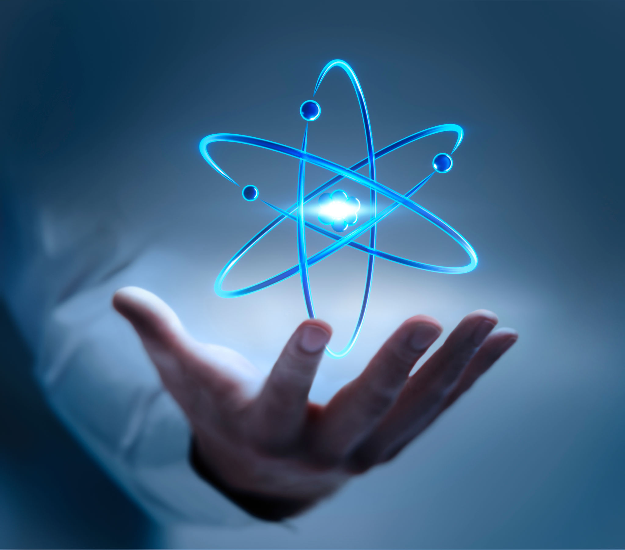 Hand with atom nucleus and electrons symbol Hand with atom nucleus and electrons symbol