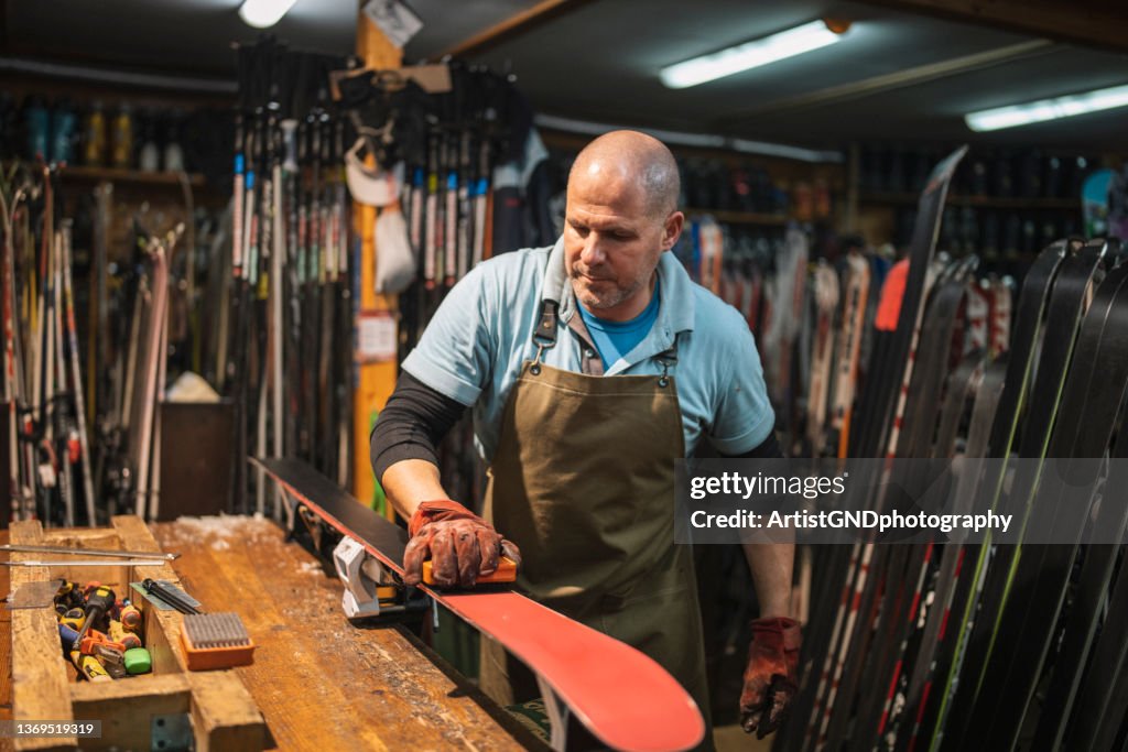 Man working in ski retail and repair shop.