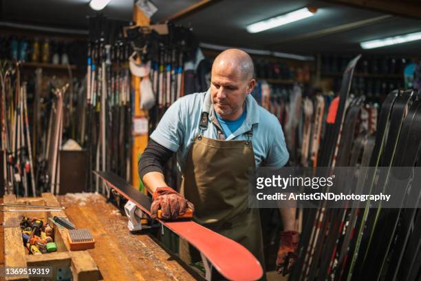 man working in ski retail and repair shop. - man skiing stock pictures, royalty-free photos & images