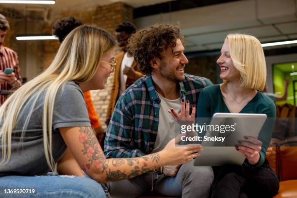 three young colleagues are sitting and talking. start-up. - agency creative stockfoto's en -beelden