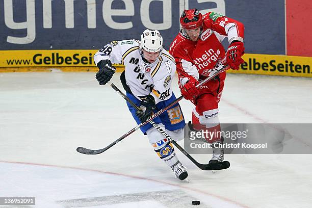 Andre Lakos of Koelner Haie uses his stick against Martin Schymainski of EHC Muenchen during the DEL match between Koelner Haie and EHC Muenchen at...