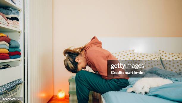 woman with stomach pain staying home - women pain stock pictures, royalty-free photos & images