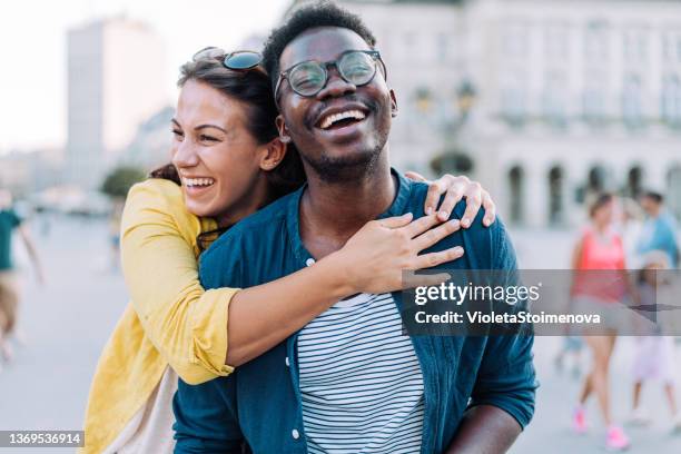 happy couple hugging outdoors. - couple laughing hugging stock pictures, royalty-free photos & images