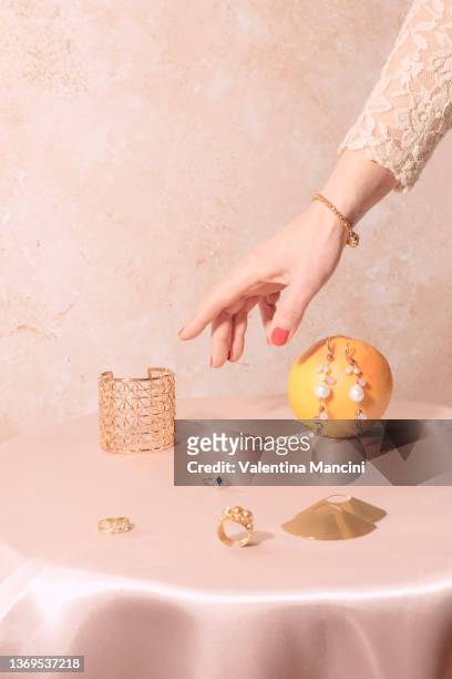 a hand fetches jewels from the table - drop earring foto e immagini stock