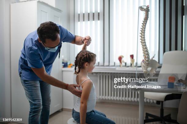 pediatrician doing development medical exam with little girl, checking spine. - scoliosis stock pictures, royalty-free photos & images