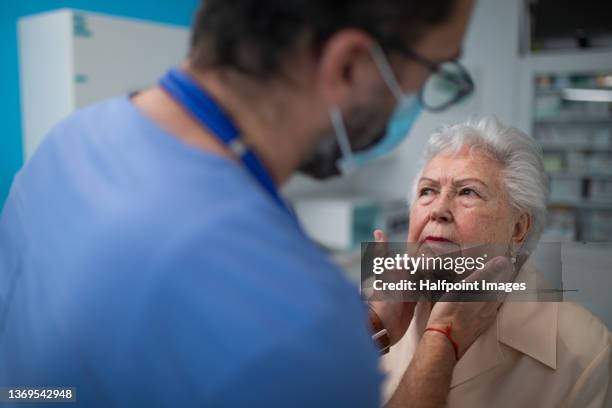 doctor checking senior woman's lymph nodes in doctor´s office. - screening of ill see you in my dreams arrivals stockfoto's en -beelden
