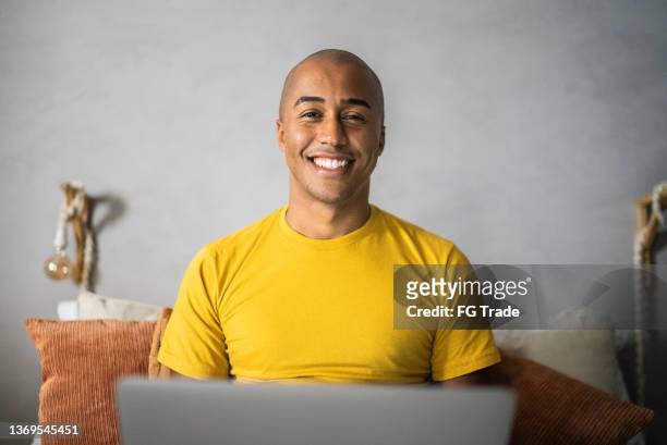retrato de um jovem usando laptop em casa - careca - fotografias e filmes do acervo