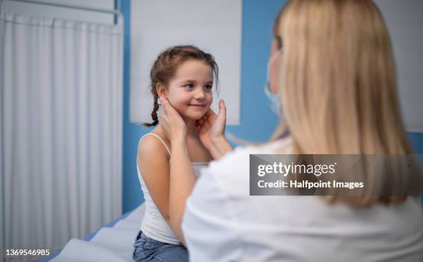 young female doctor checking little girl's  lymph nodes in her office. - lymph node stock pictures, royalty-free photos & images