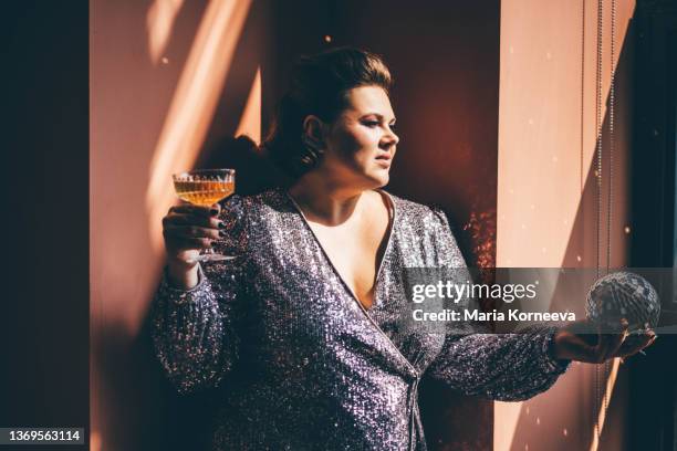 smiling woman holding champagne glass. - mitternacht stock-fotos und bilder