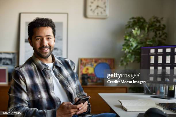 confident young businessman sitting in home office - executive man sitting at home stock pictures, royalty-free photos & images