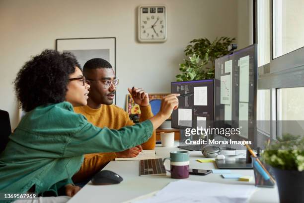 multiracial colleagues discussing over computer - small business stock pictures, royalty-free photos & images