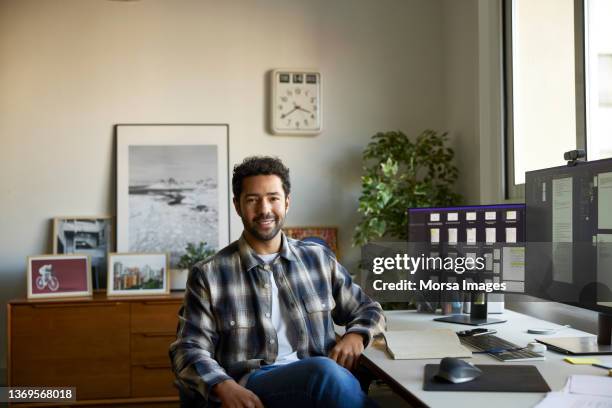 smiling businessman sitting in home office - puertorriqueño fotografías e imágenes de stock