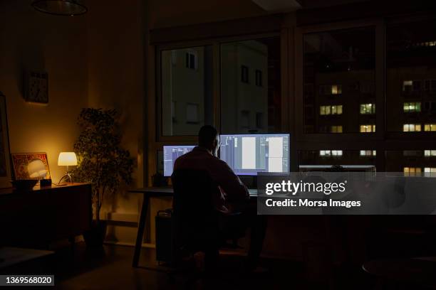 businessman using computer late at night - working late foto e immagini stock