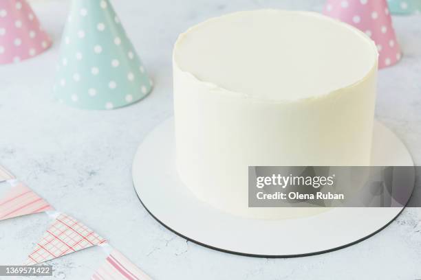 undecorated cake and many party hats. - cream colored hat stock pictures, royalty-free photos & images