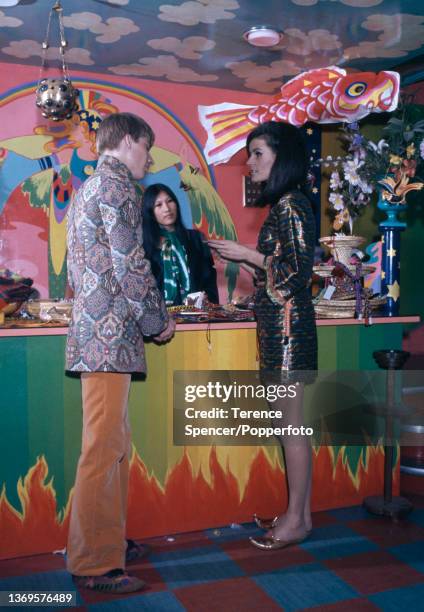 The interior of the Apple Boutique, a retail store founded by The Beatles as part of their Apple Corps business venture, a man wears a Nehru style...