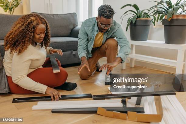 giovane coppia afro-americana che assembla nuovi mobili nell'appartamento - furniture maker foto e immagini stock