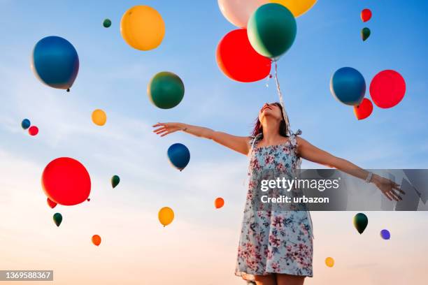 schöne frau und himmel voller luftballons - loslassen aktivitäten und sport stock-fotos und bilder