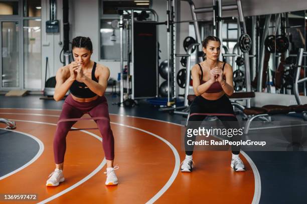 two young, smiling, happy, women exercise, stretching stepper gym. - cute bums stock pictures, royalty-free photos & images