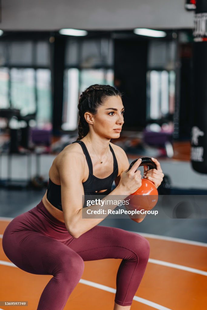 Fitness joven entrenando por kettlebell.