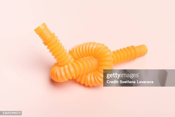 background with orange colored kids pop fidget toy - pop tube. trendy kids toys. - relax brain bildbanksfoton och bilder