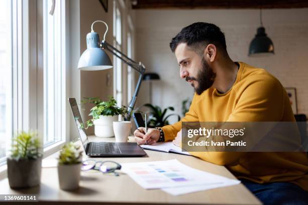 side view of a young caucasian man working from home - 自由工作者 個照片及圖片檔