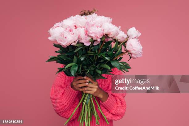 woman holding a bouquet of flowers - bouquet stockfoto's en -beelden