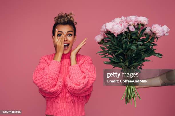 young girl accepting flowers - woman flowers stockfoto's en -beelden