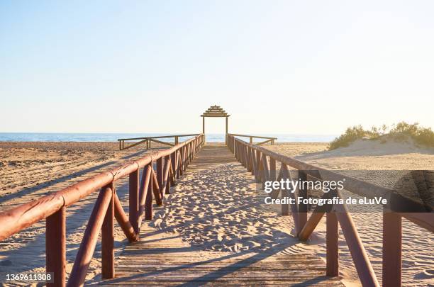 wooden boardwalk to the beach in scenic view of beach against clear sky - stakes in the sand stock pictures, royalty-free photos & images