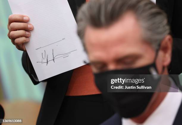 Local official holds legislation signed by California Gov. Gavin Newsom during a bill signing ceremony at Nido's Backyard Mexican Restaurant on...