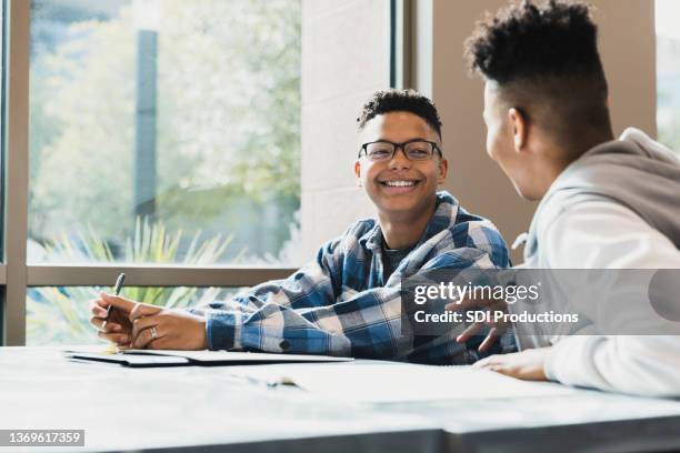 teenager hört männlichen freund zu, der geschichte erzählt - african american students stock-fotos und bilder