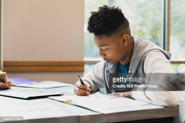 teen boy studies by himself - male writer stock pictures, royalty-free photos & images