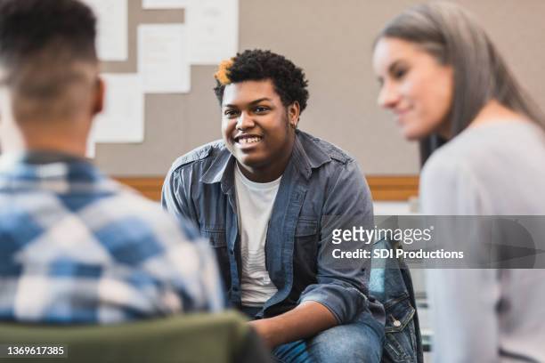 unrecognizable teacher smiles as teen welcomes new student - youth culture 個照片及圖片檔