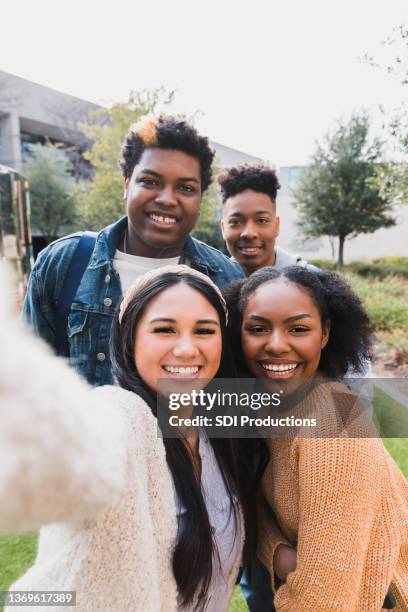 4人の十代の友人が放課後に自分撮りをする - adolescents selfie ストックフォトと画像