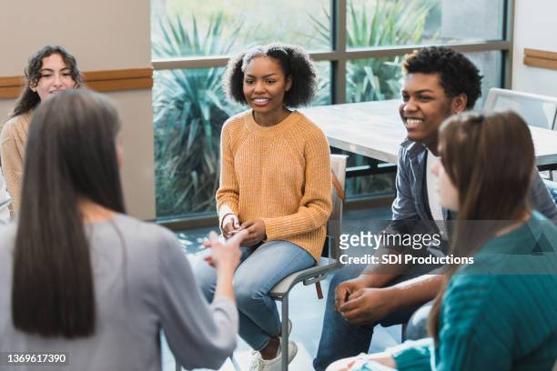unrecognizable female therapist leads teen therapy group - teen group therapy stock pictures, royalty-free photos & images