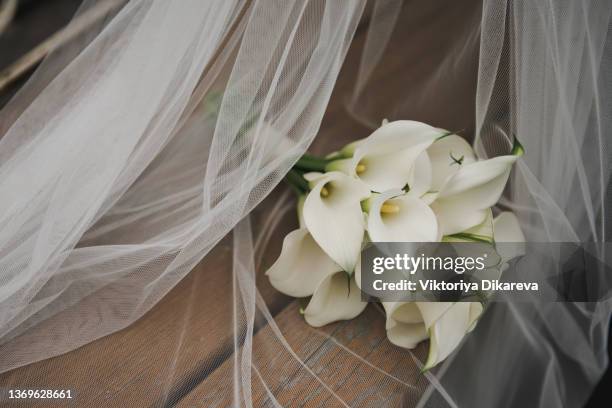 white bridal bouquet of calla lilies on the veil. - bouquet foto e immagini stock
