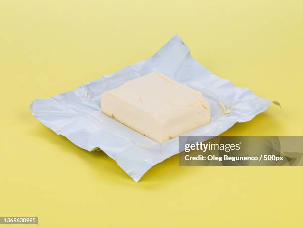 butter on yellow board,high angle view of cheese on table,moldova - knife block stock-fotos und bilder