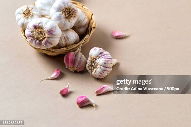 garlic cloves and garlic bulb in basket - garlic clove stock pictures, royalty-free photos & images