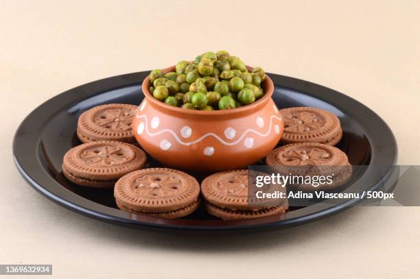 indian snack cream biscuit and spiced fried green peas - matar stock pictures, royalty-free photos & images