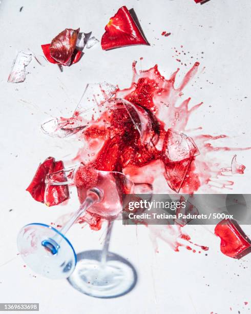 breaking glass of red wine,high angle view of red paint splashing against white background - broken drinking glass stock pictures, royalty-free photos & images