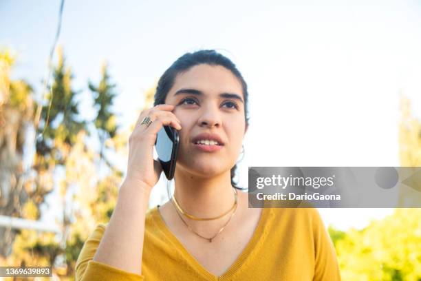 mujer joven hablando por teléfono - personas hablando stock pictures, royalty-free photos & images