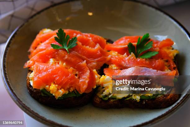 grated egg avocado toast with raw salmon, trendy breakfast. - redfish stockfoto's en -beelden