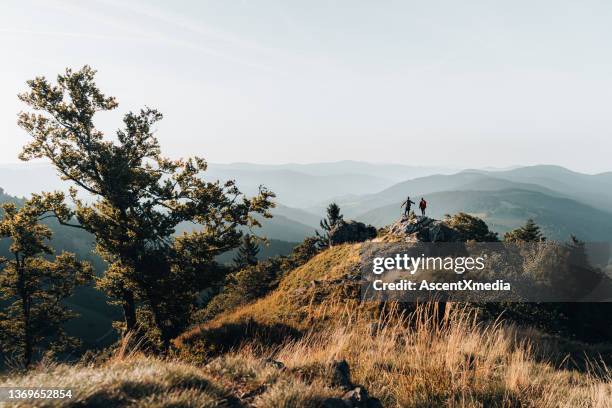 young couple backpack up a mountain summit - black forest germany stock pictures, royalty-free photos & images