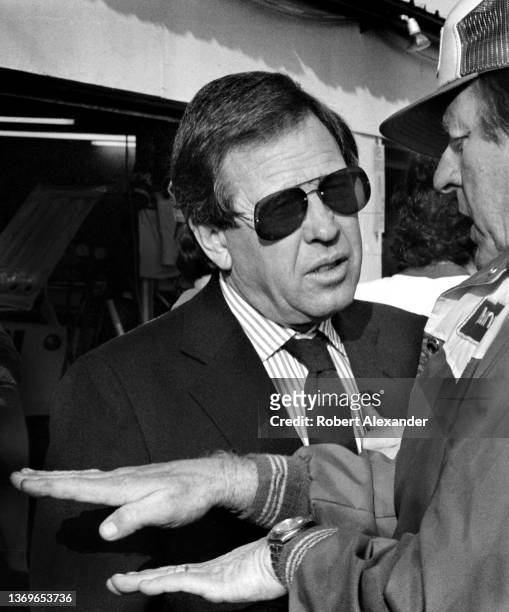 Bill France Jr., left, talks with racecar owner Bud Moore in the speedway garage prior to the start of the 1983 Daytona 500 stock car race at Daytona...