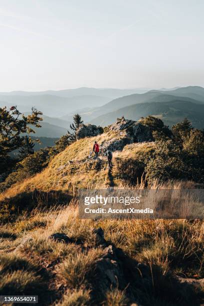 young couple backpack up a mountain summit - distance stock pictures, royalty-free photos & images