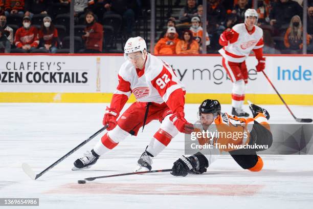 Vladislav Namestnikov of the Detroit Red Wings and Travis Konecny of the Philadelphia Flyers challenge for the puck during the first period at Wells...