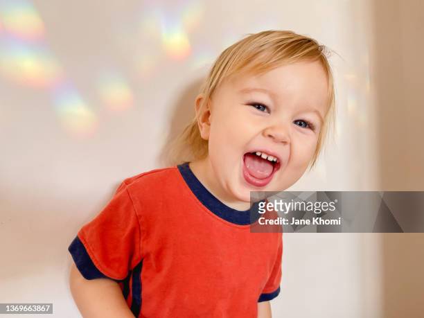 little boy laughing and a rainbow - rainbow kids stock-fotos und bilder