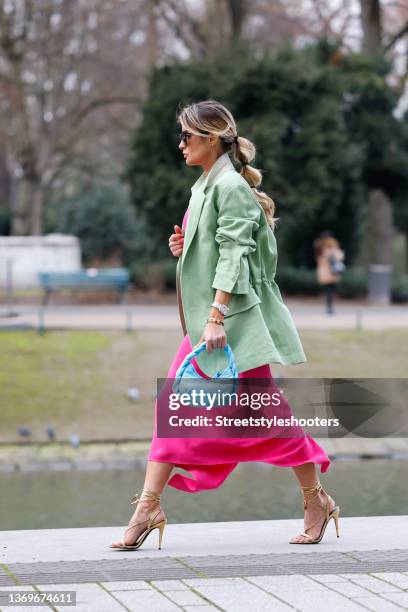 Influencer Gitta Banko wearing a low bubble ponytail hairstyle, a pink maxi dress by Petar Petrov, a pastel green jacket by Petar Petrov, a light...